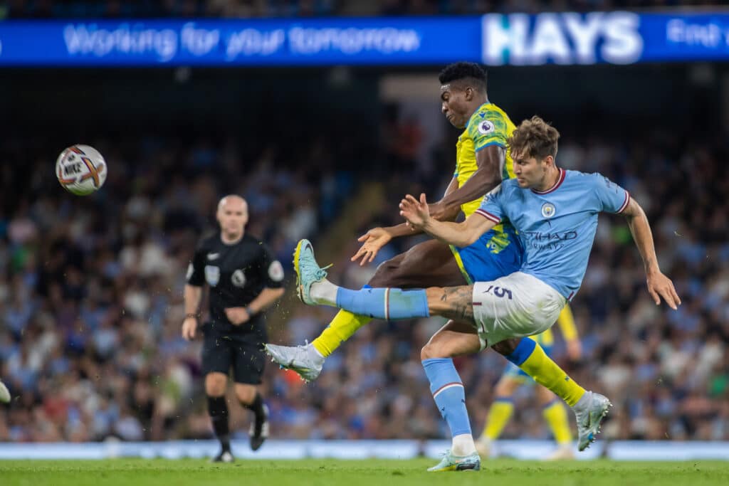 Taiwo Awoniyi #9 of Nottingham Forest looks to close down John Stones #5 of Manchester City